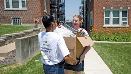Two students carry a box of donations at the Share Our Stuff event.
